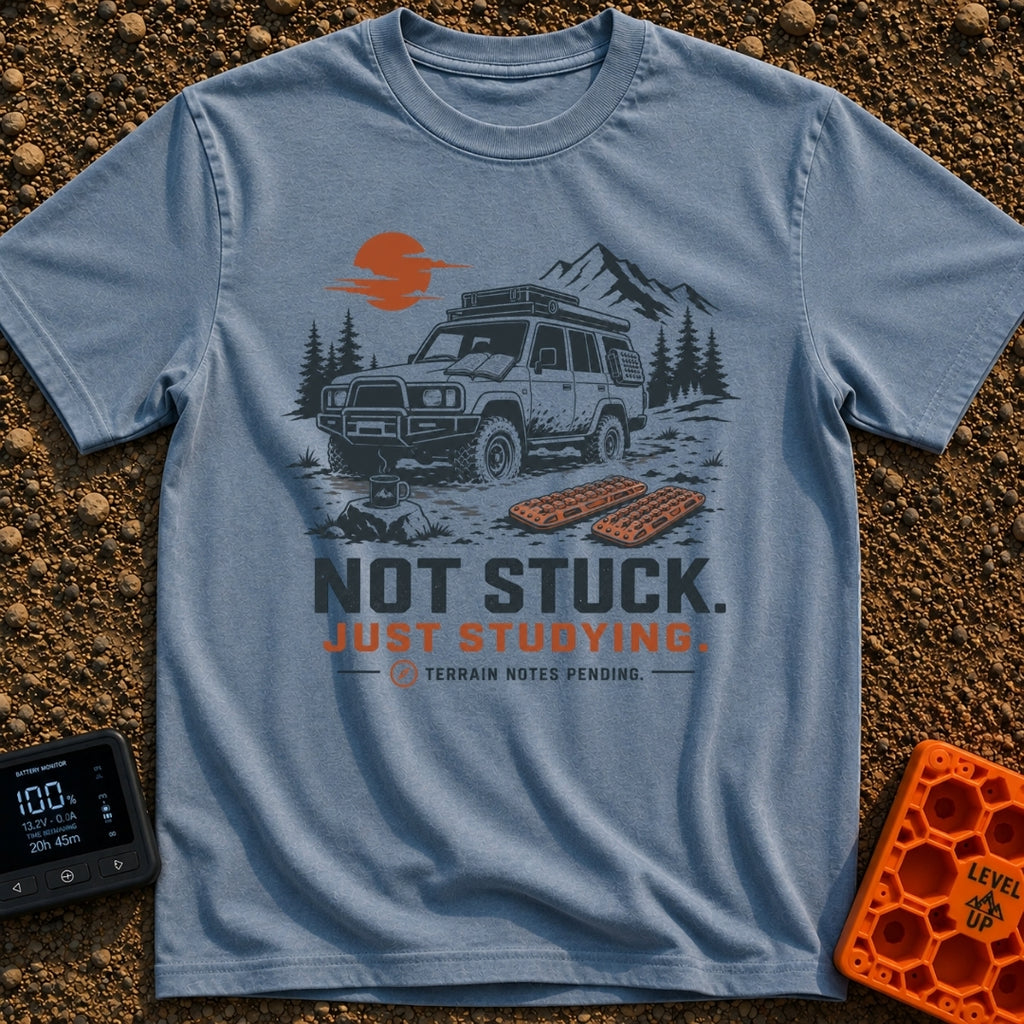 Not Stuck Just Studying - T-Shirt in Blue Jean - An illustration of a muddy 4x4 SUV stopped on a rugged trail, with an...