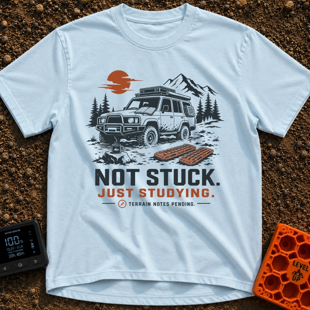Not Stuck Just Studying - T-Shirt in Chambray - An illustration of a muddy 4x4 SUV stopped on a rugged trail, with an...