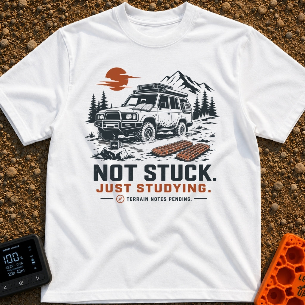 Not Stuck Just Studying - T-Shirt in White - An illustration of a muddy 4x4 SUV stopped on a rugged trail, with an open...