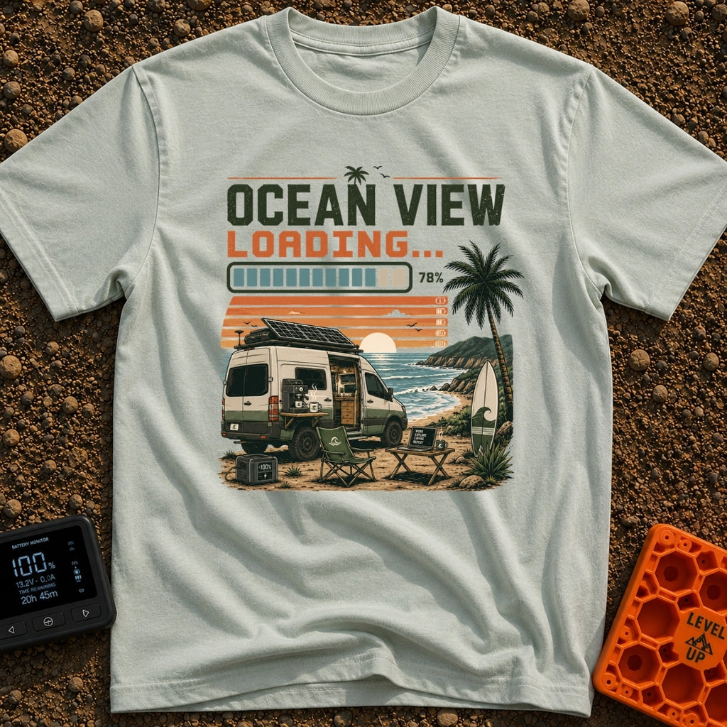 Ocean View Loading - T-Shirt in Bay - A camper van is parked by the ocean at sunset with a roof-mounted solar panel and a...