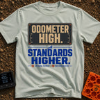 High Miles Higher Standards - T-Shirt in Bay - A typographic design featuring the text "ODOMETER HIGH." in tan letters on...