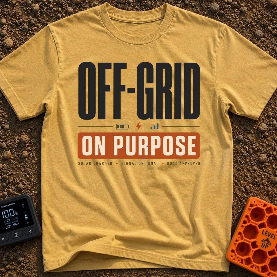 Off Grid On Purpose - T-Shirt in Mustard - A typographic design reading "OFF-GRID" in large text above a battery,...