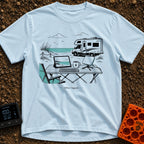 The New Corner Office - T-Shirt in Chambray - A line-art illustration of an outdoor workspace set up on a beach in front...