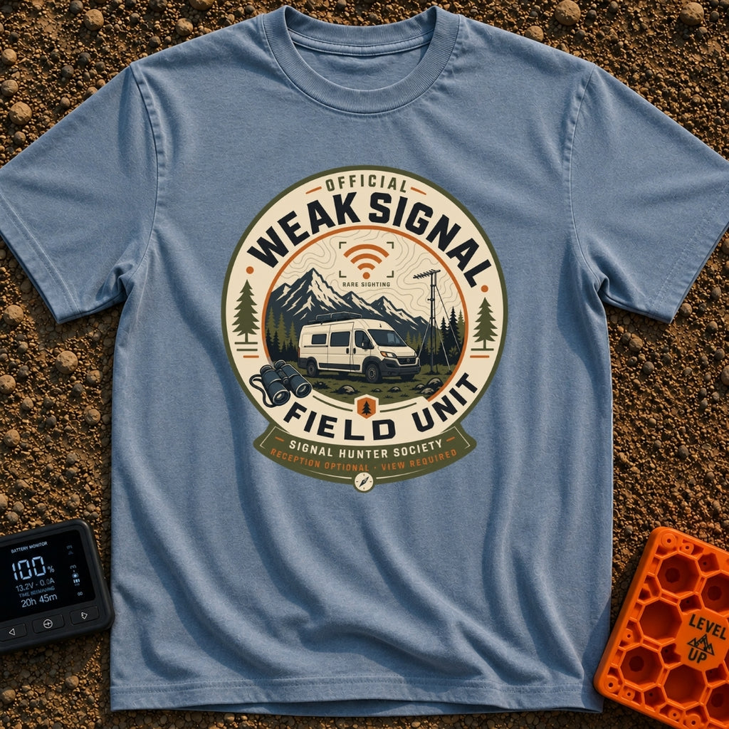 Weak Signal Field Unit - T-Shirt in Blue Jean - A round, badge-style illustration of a white camper van parked in a...