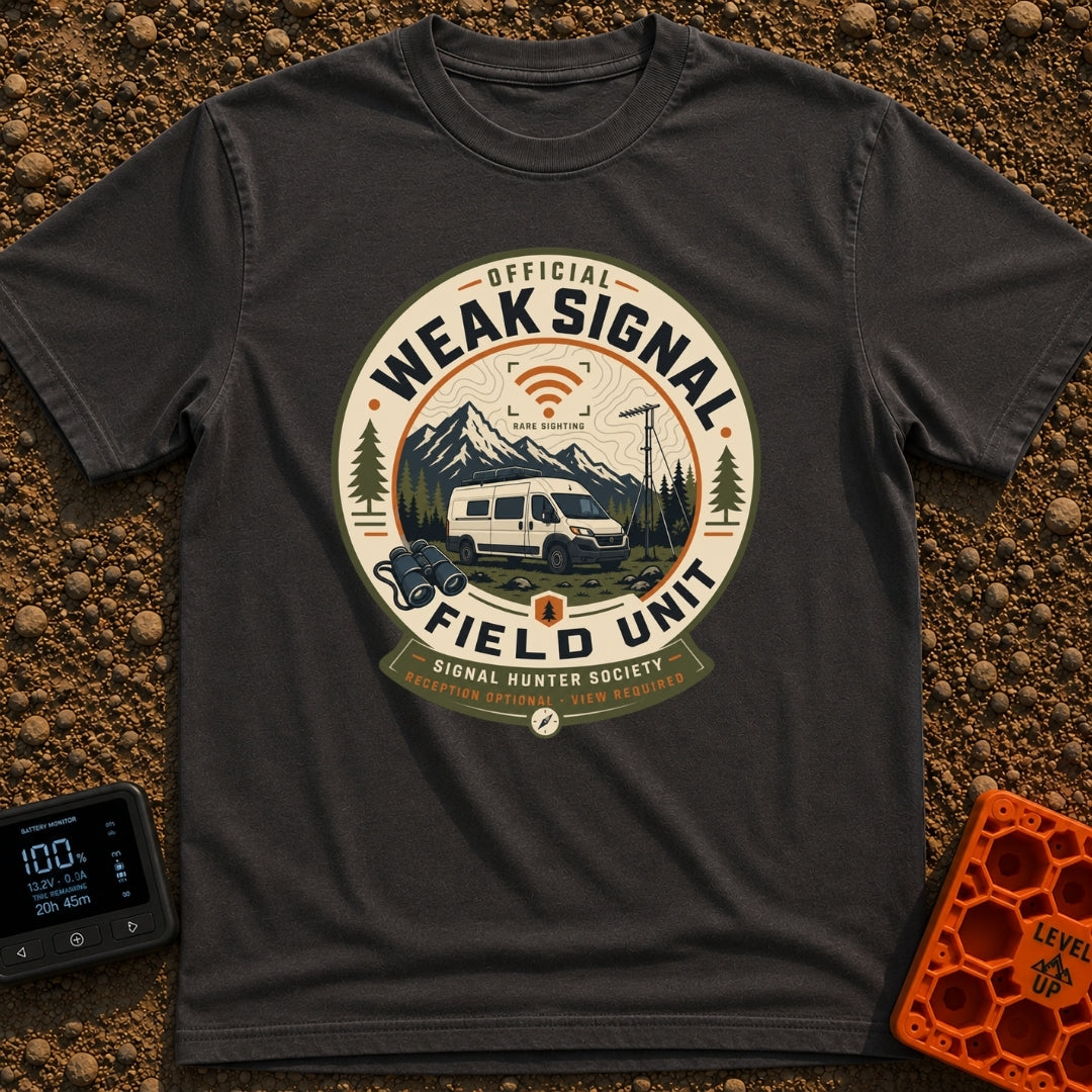Weak Signal Field Unit - T-Shirt in Graphite - A round, badge-style illustration of a white camper van parked in a...