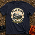 Weak Signal Field Unit - T-Shirt in Navy - A round, badge-style illustration of a white camper van parked in a...