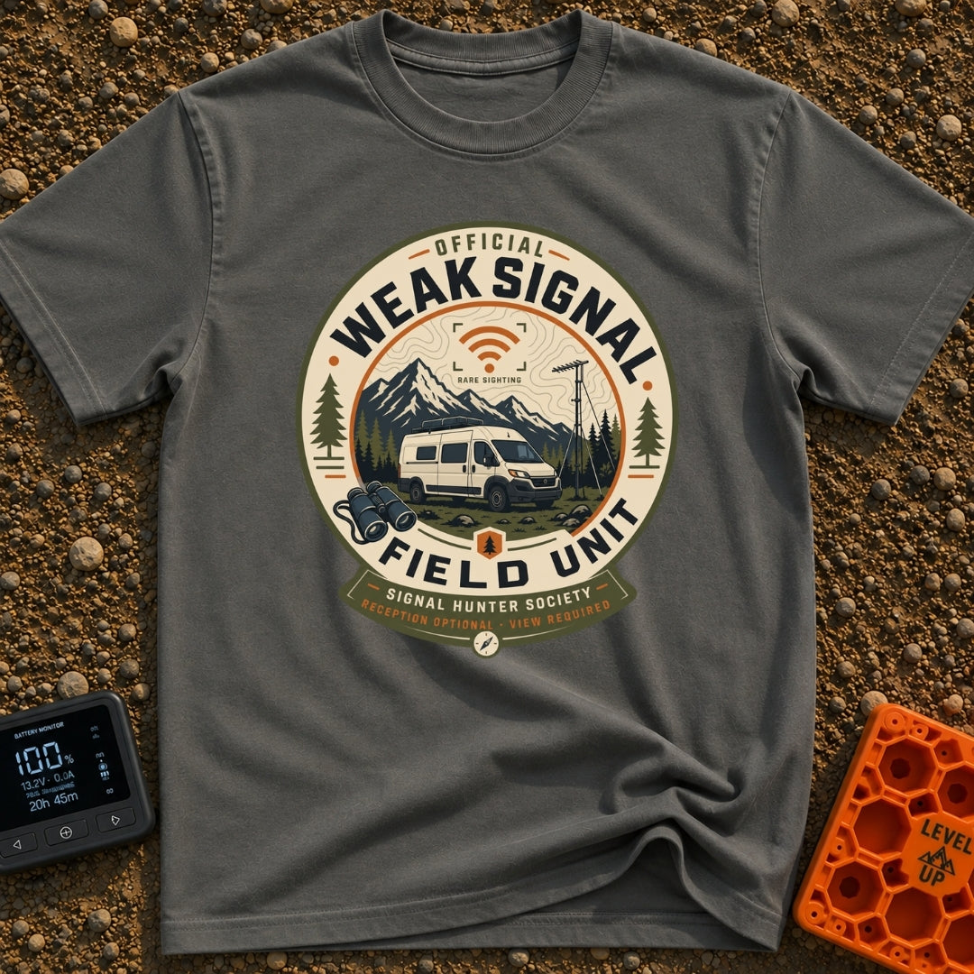 Weak Signal Field Unit - T-Shirt in Pepper - A round, badge-style illustration of a white camper van parked in a...