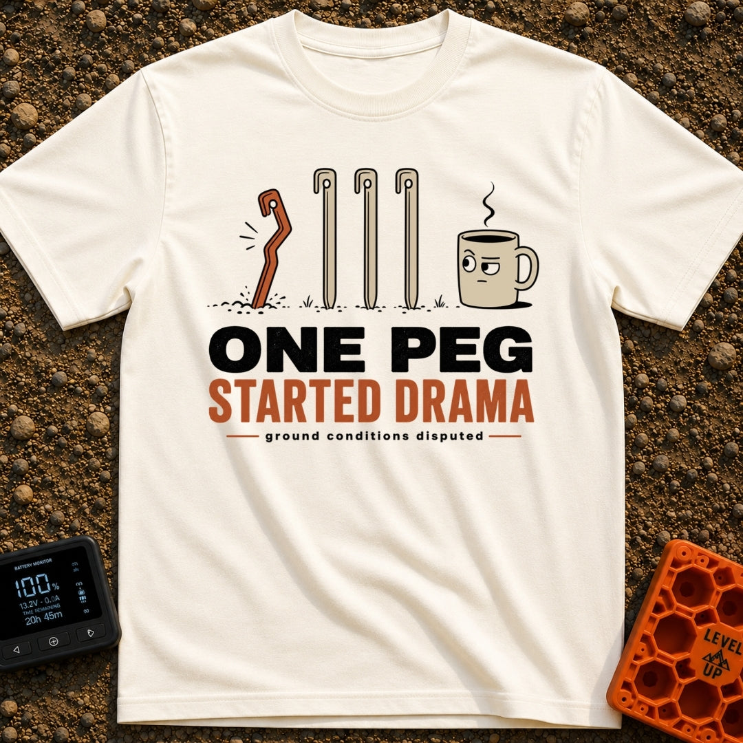 One Peg Started Drama - T-Shirt in Ivory - A cartoon illustration showing four tent pegs driven into the ground, with the...