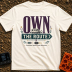 Own The Route - T-Shirt in Ivory - The design features the large text "OWN" behind a white camper van, with the words...