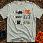 Park Level Repeat - T-Shirt in Bay - A three-step checklist graphic featuring the words "PARK.", "LEVEL.", and "REPEAT."...