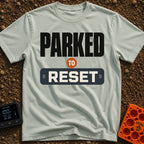 Parked To Reset - T-Shirt in Bay - A typographic design that reads "PARKED TO RESET". The word "PARKED" is in large black...