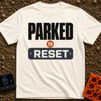Parked To Reset - T-Shirt in Ivory - A typographic design that reads "PARKED TO RESET". The word "PARKED" is in large...