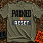 Parked To Reset - T-Shirt in Moss - A typographic design that reads "PARKED TO RESET". The word "PARKED" is in large...