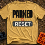 Parked To Reset - T-Shirt in Mustard - A typographic design that reads "PARKED TO RESET". The word "PARKED" is in large...