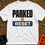 Parked To Reset - T-Shirt in White - A typographic design that reads "PARKED TO RESET". The word "PARKED" is in large...