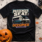 Technically Riding Shotgun - T-Shirt in Black - A white camper van with mountain graphics on its side, featuring a...