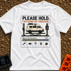 Fixing My Freedom - T-Shirt in White - A white camper van is shown elevated on a green auto lift beneath the text "PLEASE...