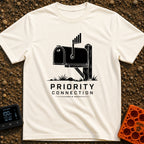 Priority Mail Connection - T-Shirt in Ivory - A black and white illustration of a classic roadside mailbox on a wooden...
