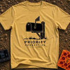 Priority Mail Connection - T-Shirt in Mustard - A black and white illustration of a classic roadside mailbox on a wooden...