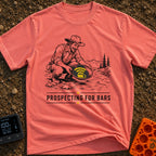 Panning For Signal - T-Shirt in Watermelon - A black and white illustration of a gold prospector squatting by a stream,...