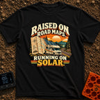 Raised On Roadmaps - T-Shirt in Black - A retro-style motorhome with a large solar panel on its roof drives along a...