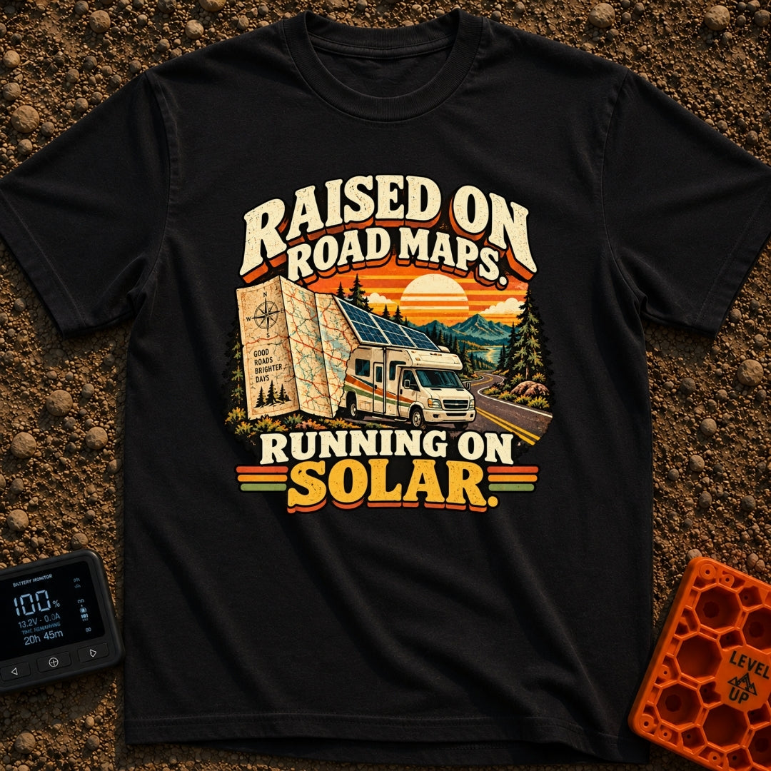 Raised On Roadmaps - T-Shirt in Black - A retro-style motorhome with a large solar panel on its roof drives along a...