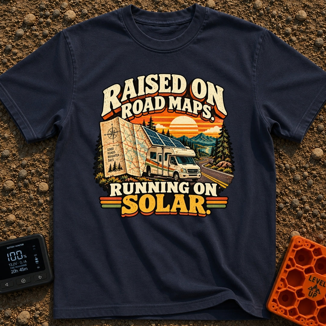 Raised On Roadmaps - T-Shirt in Navy - A retro-style motorhome with a large solar panel on its roof drives along a...