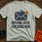 Reply Later Explore Now - T-Shirt in Bay - A graphic of a dark grey email envelope where the top flap is shaped like a...