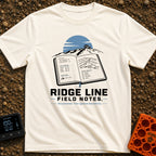 Ridge Top Chronicles - T-Shirt in Ivory - An open notebook showing GPS coordinates, tyre pressure logs, a mountain...