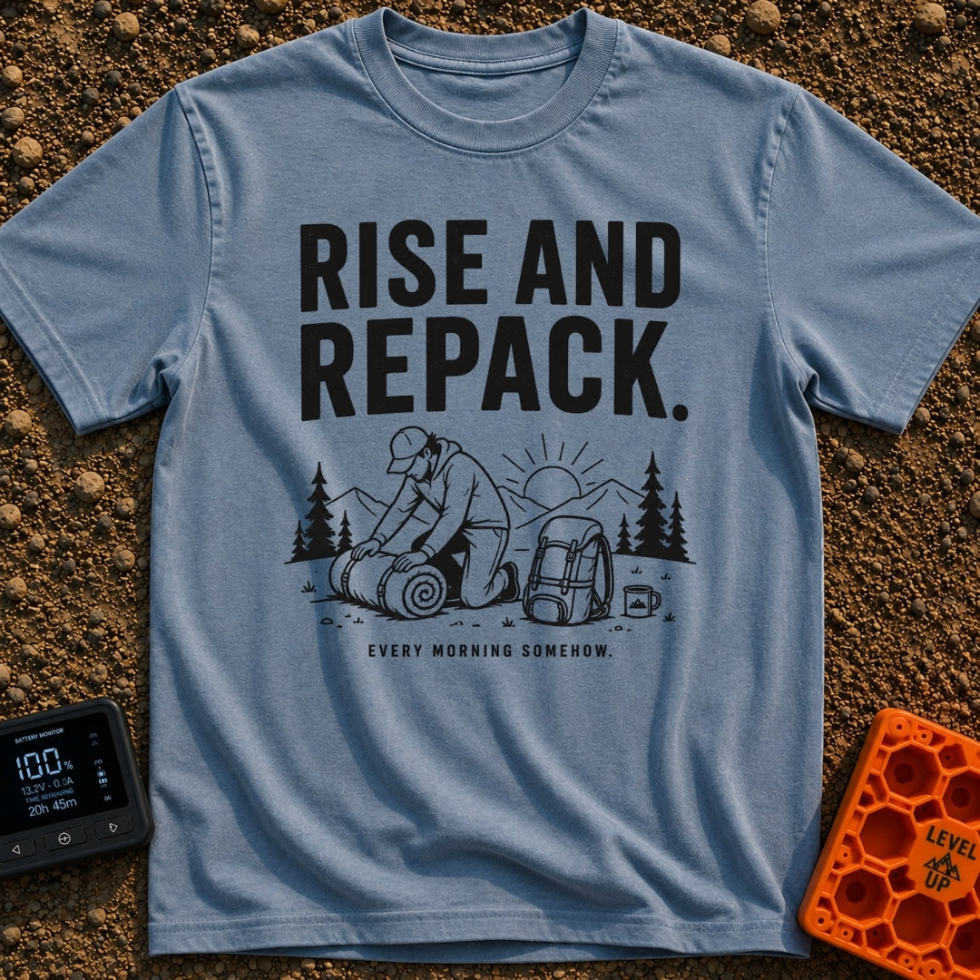 Rise And Repack - T-Shirt in Blue Jean - A black-and-white illustration of a man kneeling to roll up a sleeping bag, with...
