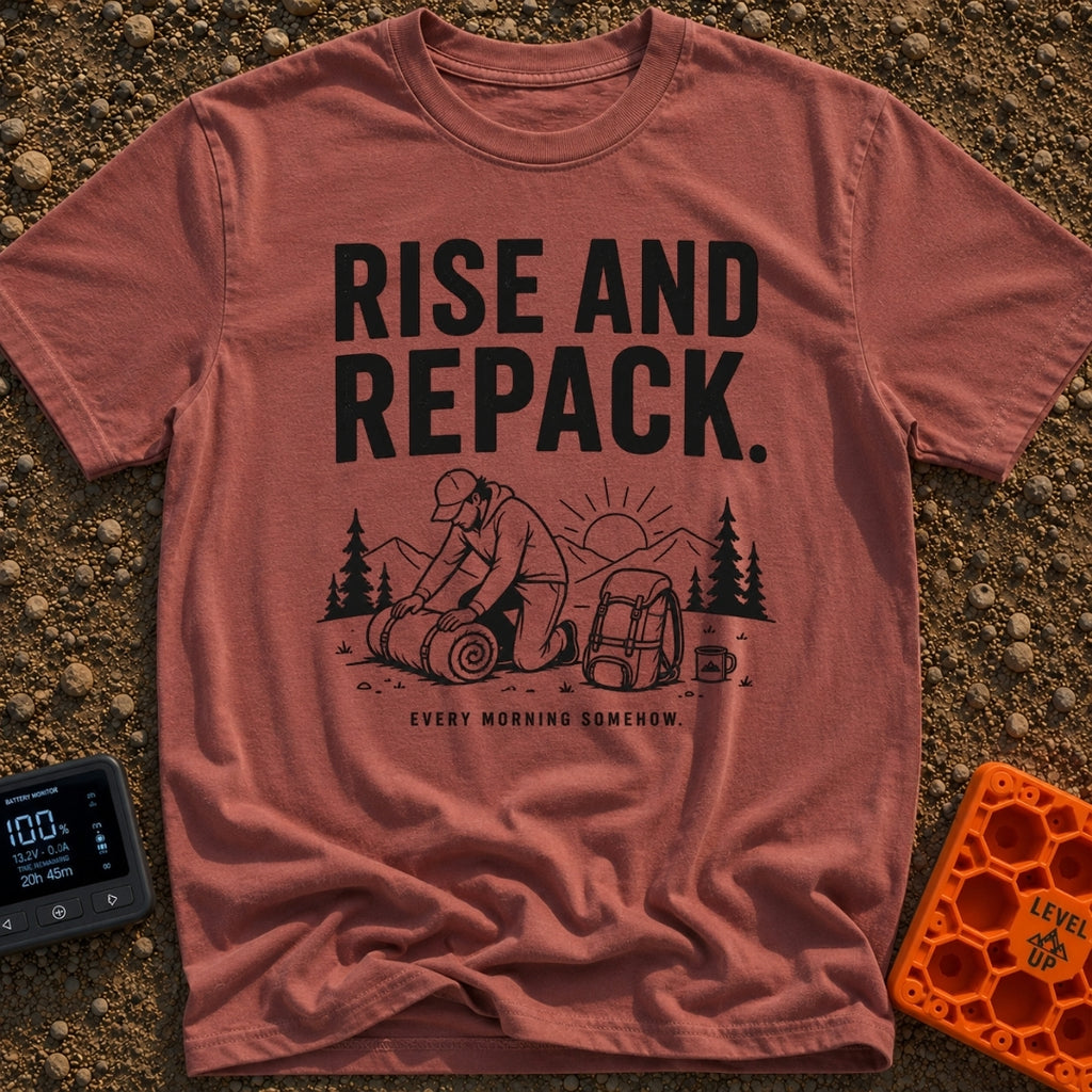 Rise And Repack - T-Shirt in Brick - A black-and-white illustration of a man kneeling to roll up a sleeping bag, with a...