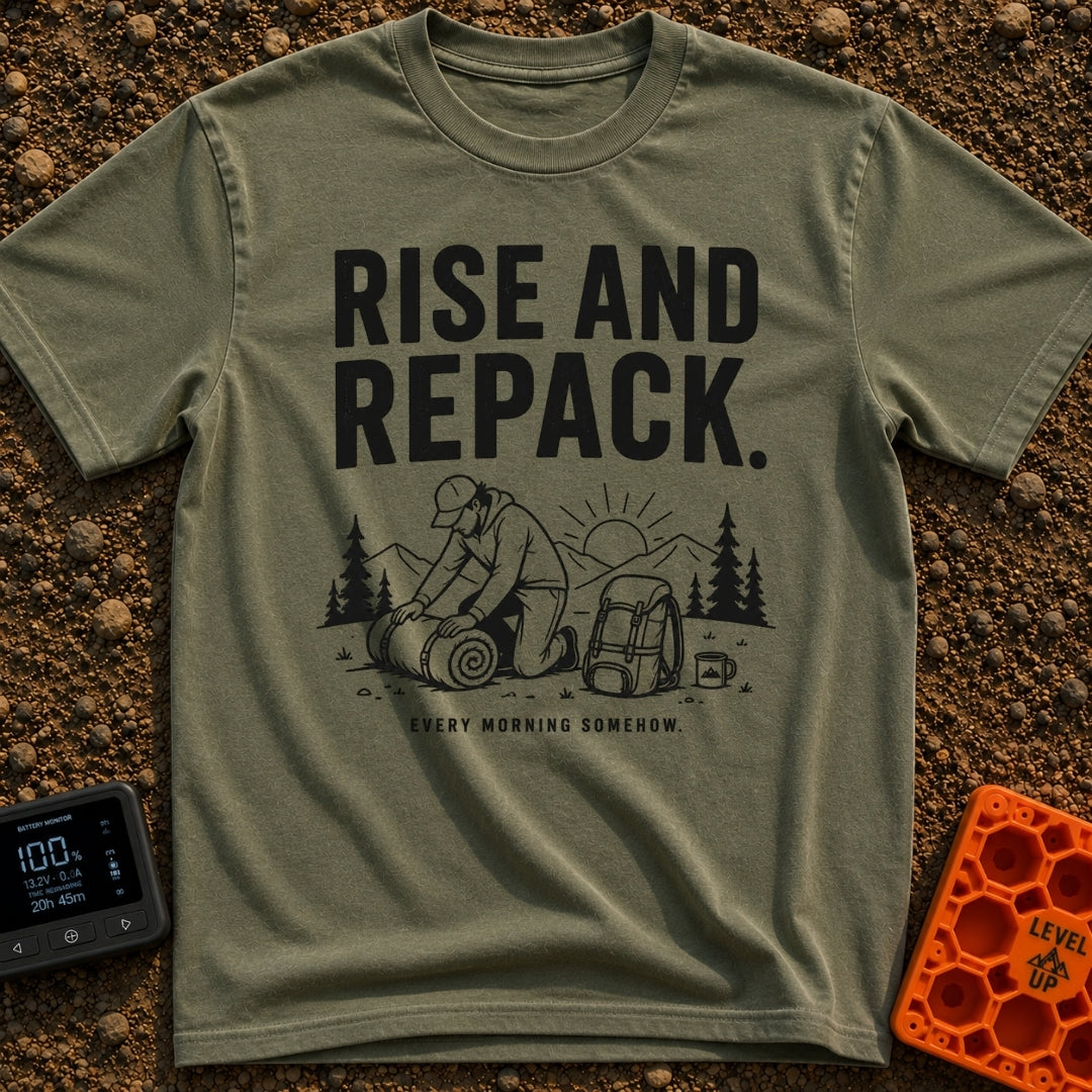 Rise And Repack - T-Shirt in Moss - A black-and-white illustration of a man kneeling to roll up a sleeping bag, with a...
