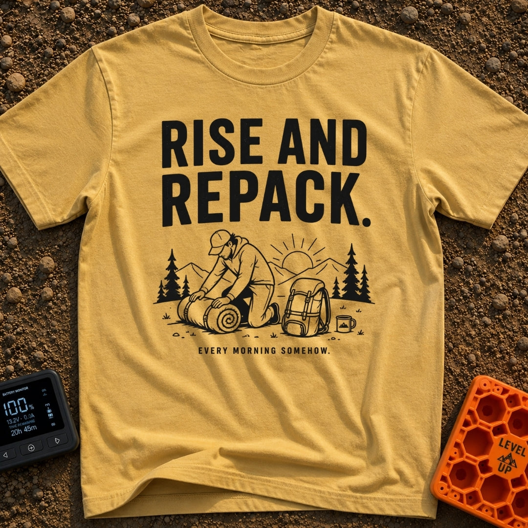 Rise And Repack - T-Shirt in Mustard - A black-and-white illustration of a man kneeling to roll up a sleeping bag, with a...