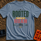 Rooted To Roam - T-Shirt in Blue Jean - The design features the text "ROOTED ENOUGH TO ROAM" with tree roots growing from...