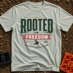 Grounded To Roam - T-Shirt in Bay - A typographic design reading "ROOTED IN FREEDOM" with roots growing from the letters,...