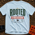 Grounded To Roam - T-Shirt in Chambray - A typographic design reading "ROOTED IN FREEDOM" with roots growing from the...