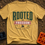 Grounded To Roam - T-Shirt in Mustard - A typographic design reading "ROOTED IN FREEDOM" with roots growing from the...