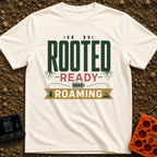 Rooted To Roam - T-Shirt in Ivory - A typographic design reading "ROOTED", "READY", and "ROAMING" stacked vertically. The...