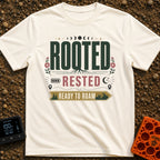 Rooted Ready To Roam - T-Shirt in Ivory - A typographic design featuring the word "ROOTED" with tree roots growing from...
