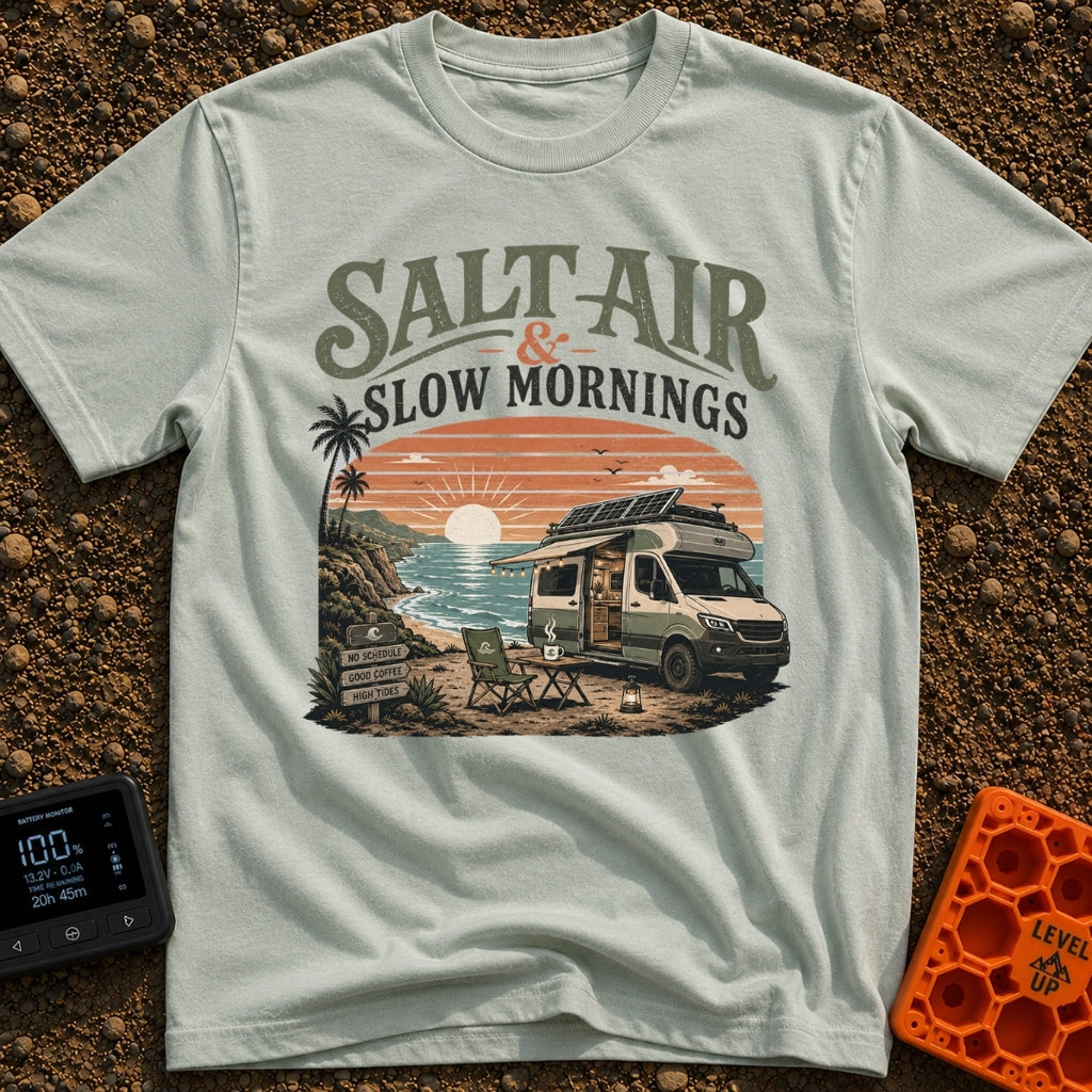 Sunrise Sips & Sea - T-Shirt in Bay - A camper van is parked on a coastal cliff overlooking the ocean at sunrise, with a...