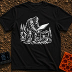 Sasquatch Seeking Signal - T-Shirt in Black - A black-and-white illustration of a Sasquatch adjusting a flat satellite...