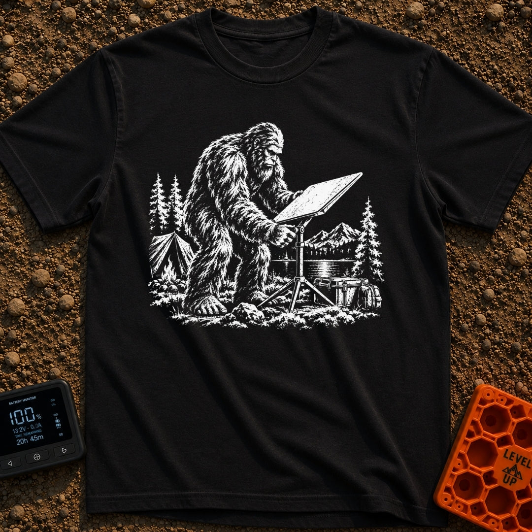 Sasquatch Seeking Signal - T-Shirt in Black - A black-and-white illustration of a Sasquatch adjusting a flat satellite...