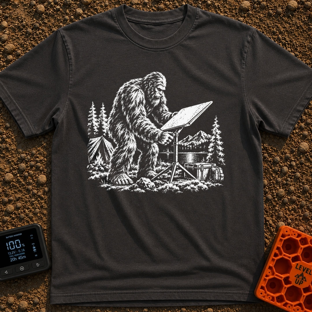 Sasquatch Seeking Signal - T-Shirt in Graphite - A black-and-white illustration of a Sasquatch adjusting a flat satellite...