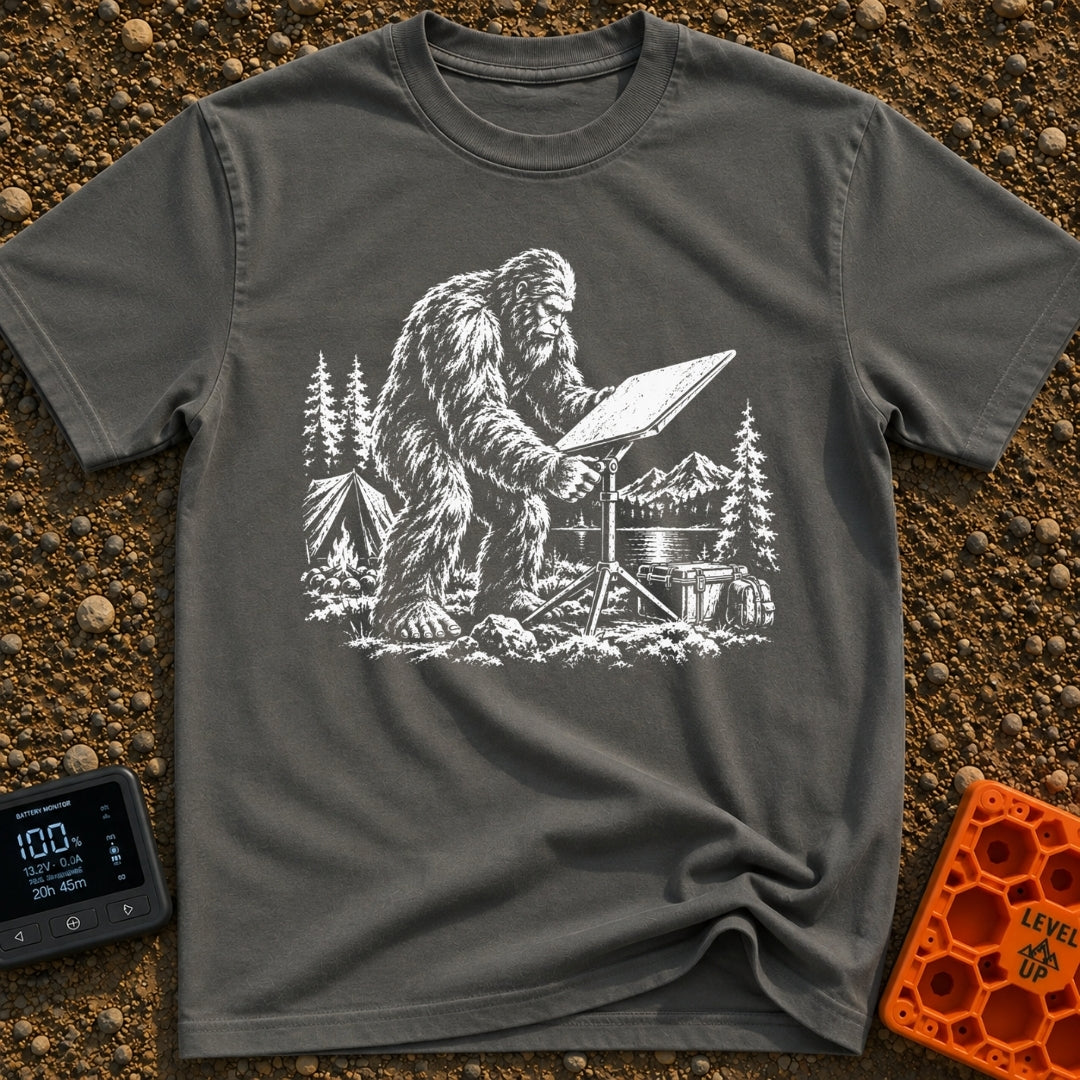 Sasquatch Seeking Signal - T-Shirt in Pepper - A black-and-white illustration of a Sasquatch adjusting a flat satellite...