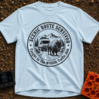 Survived The Scenic Route - T-Shirt in Chambray - A circular, black-and-white illustration of a camper van stopped on a...
