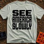 Go Slow, America - T-Shirt in Bay - Bold, black, block text stacked in three lines reading 'SEE AMERICA SLOWLY' on a...
