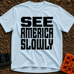 Go Slow, America - T-Shirt in Chambray - Bold, black, block text stacked in three lines reading 'SEE AMERICA SLOWLY' on a...