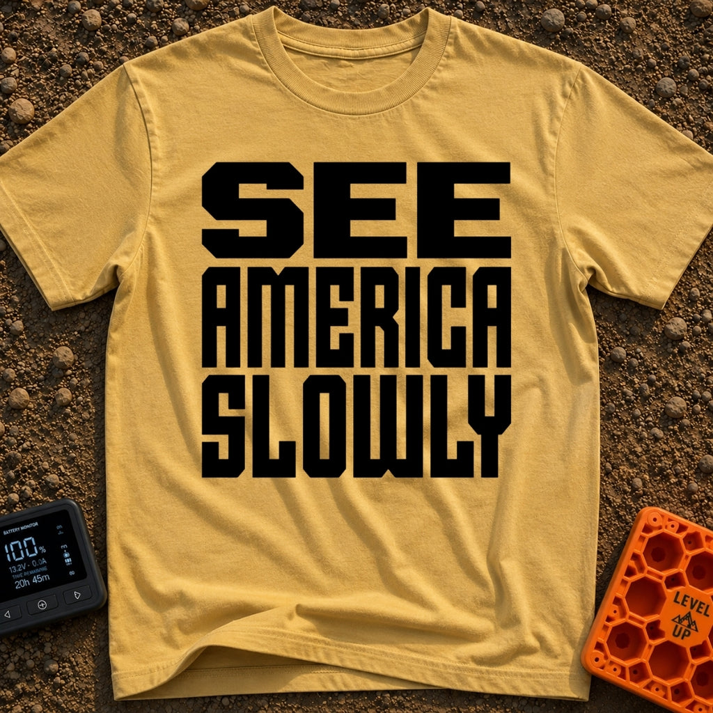 Go Slow, America - T-Shirt in Mustard - Bold, black, block text stacked in three lines reading 'SEE AMERICA SLOWLY' on a...