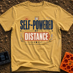 Charged By Distance - T-Shirt in Mustard - A typographic design reading "SELF-POWERED BY DISTANCE" with the word...