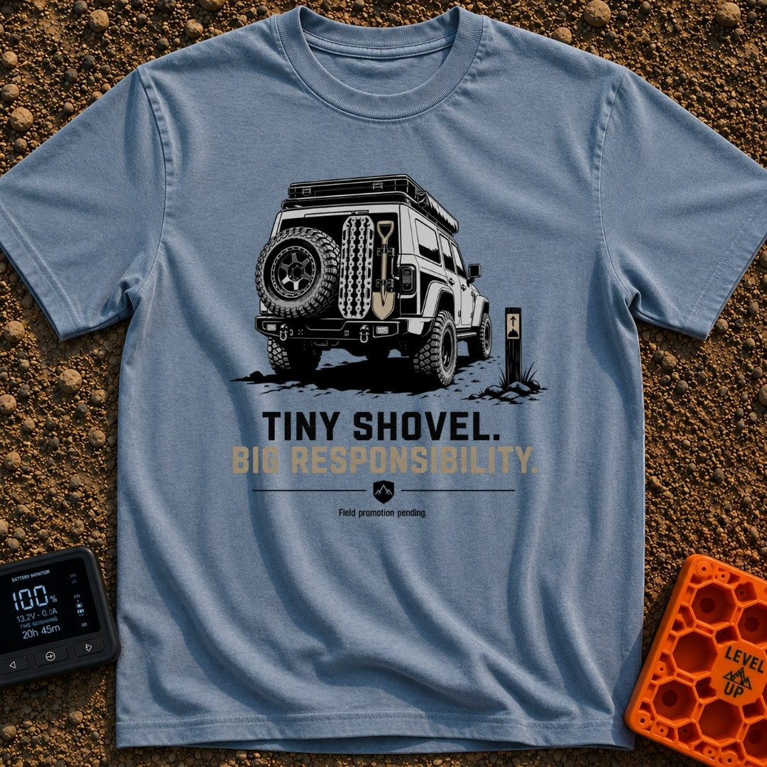 Dig Tiny Adventures - T-Shirt in Blue Jean - A rear-view illustration of a rugged 4x4 off-road vehicle parked near a...